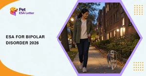 ESA for bipolar disorder: a woman in an olive jacket walking a small grey-and-white terrier along a tree-lined apartment street at dusk, the evening walk kept at the same time every day